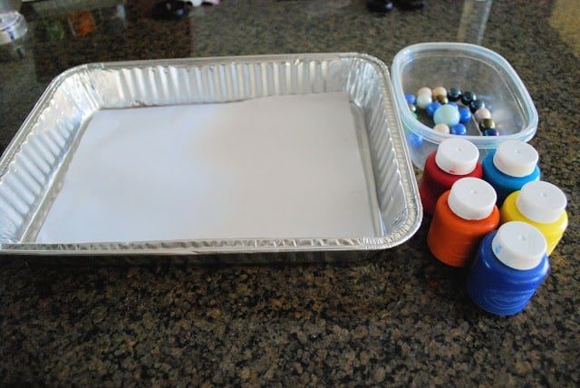 paint, paper in a tray and marbles