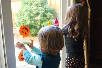 children placing foam pumpkins on windows