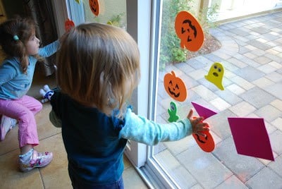 children placing foam pumpkins on windows