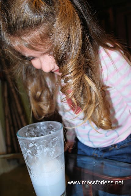 child mixing baking soda and vinegar