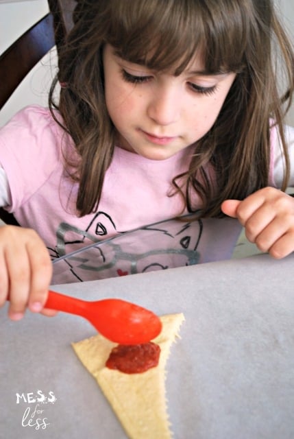 child making pepperoni pizza crescents