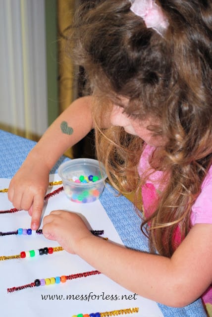 child counting beads on pipe cleaners