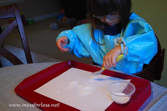 child pouring salt on paper