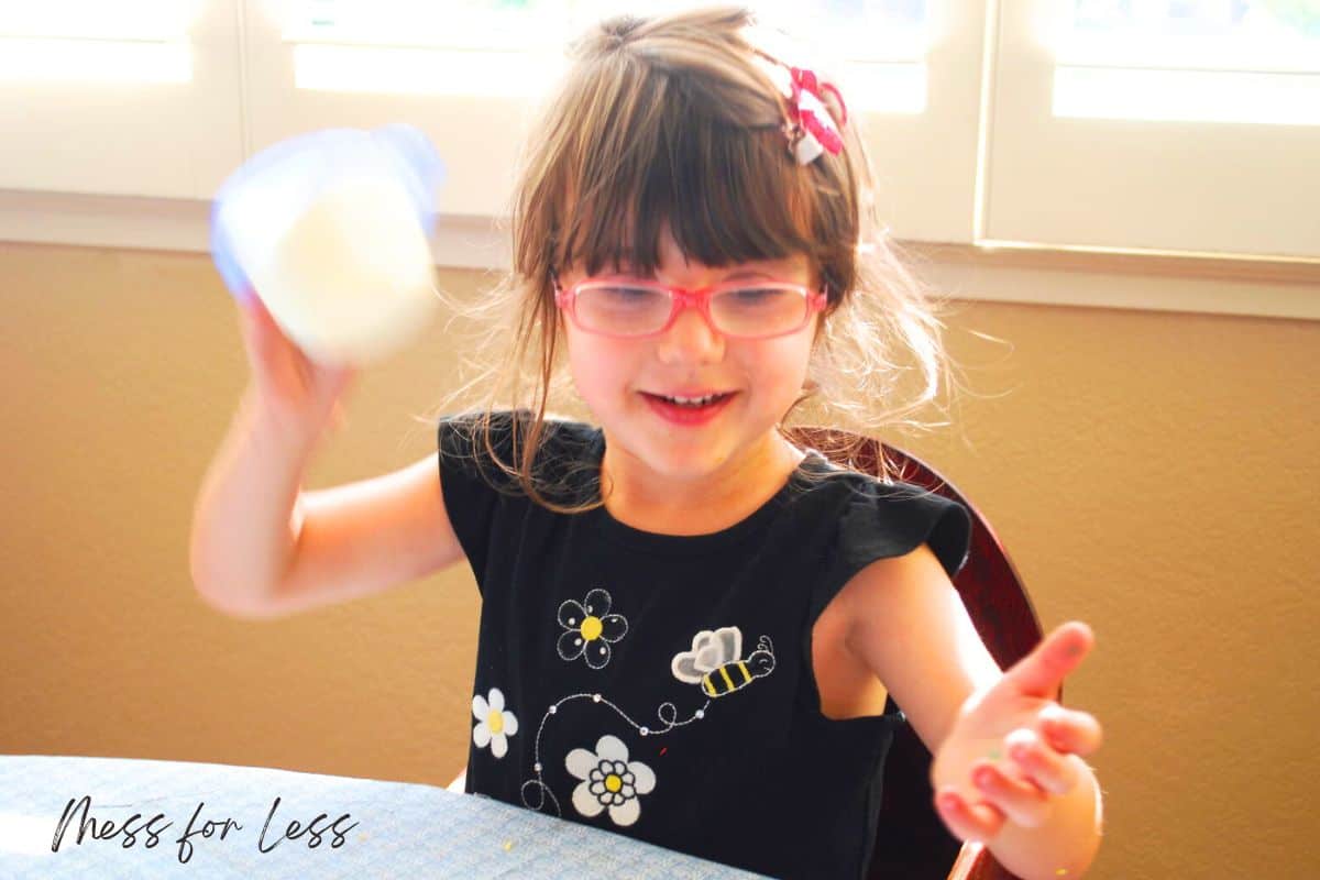 child shaking container with cream to make homemade butter