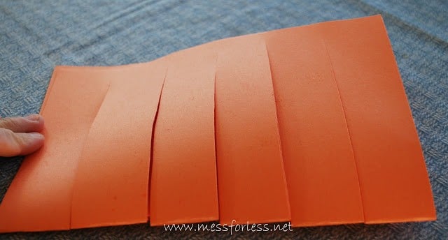 orange construction paper with cuts in it
