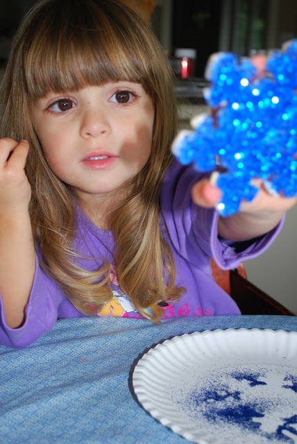 child holding glitter ornament
