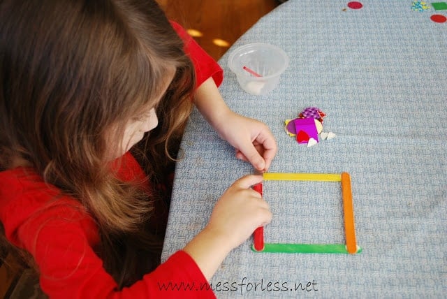 child making frame with colored popsicle sticks