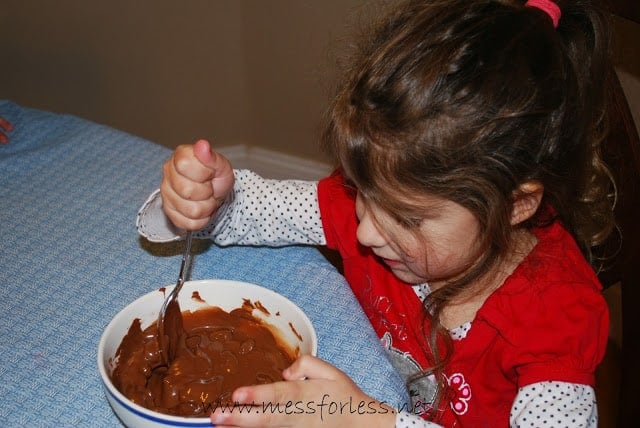 child stirring melted chocolate
