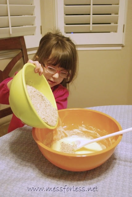 child pouring oatmeal in a bowl