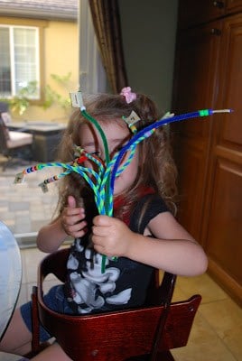 child holding pipe cleaners