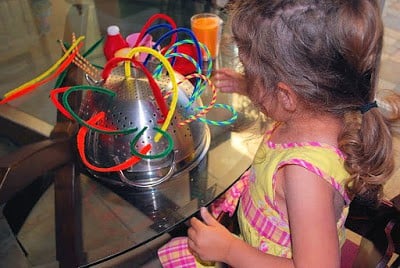placing pipe cleaners in colander