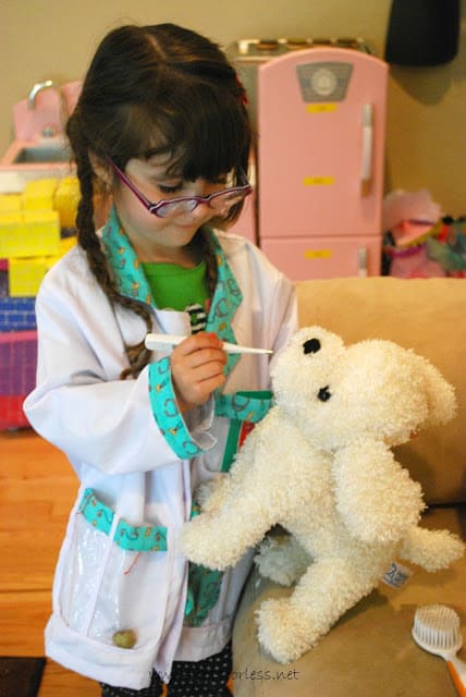 child taking stuffed animal's temperature