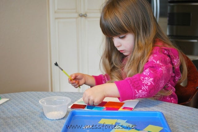 child making tissue paper square collage