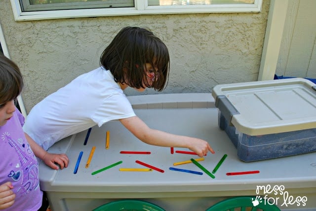 child counting popsicle sticks