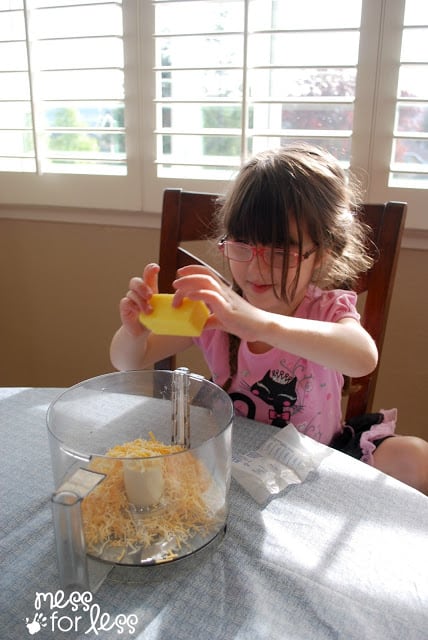 child placing butter in food processor