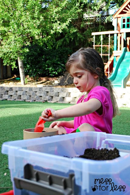 child placing dirt in pot