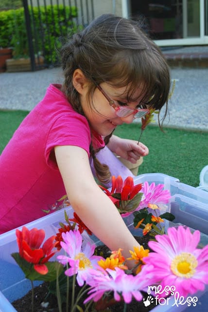 child working in a garden sensory bin