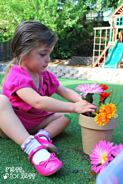 child planting artificial flowers