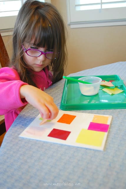 child placing tissue paper on canvas