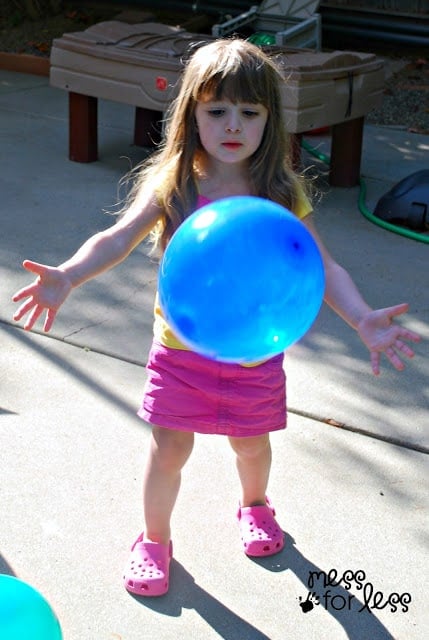 child playing with blue balloon