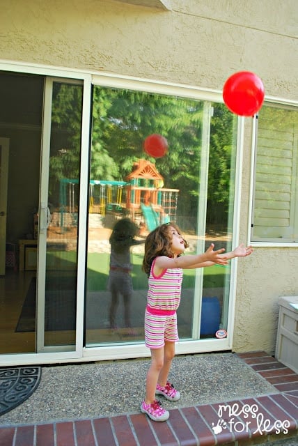 child playing with red balloon