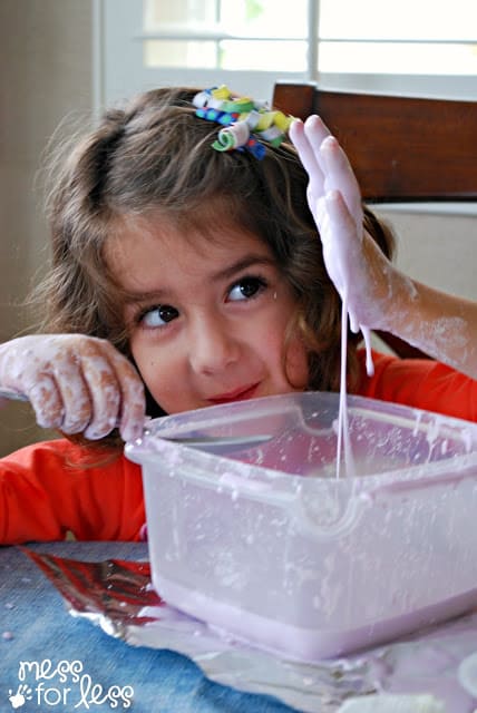 child with pink oobleck on their hands
