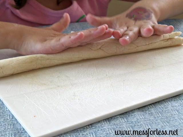 child rolling out dough