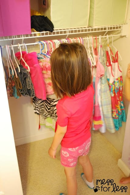 child picking out clothes in closet