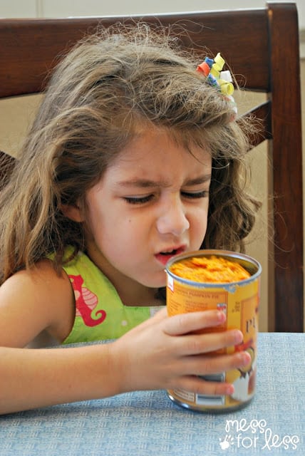 child smelling canned pumpkin