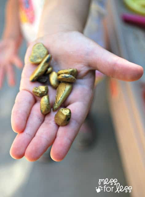 child holding gold rocks in hand