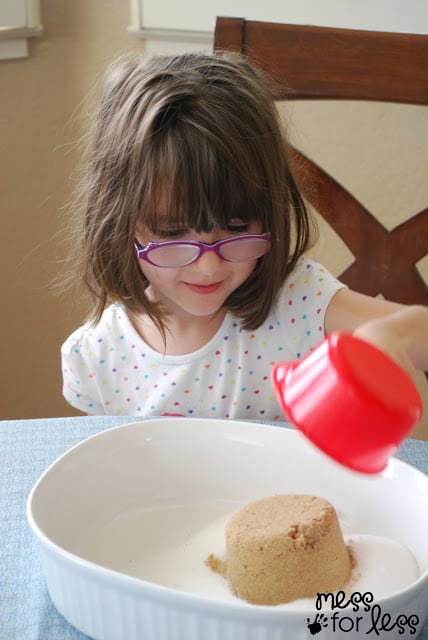 child placing brown sugar in a bowl
