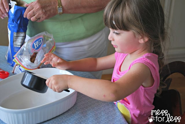 child holding measuring cup