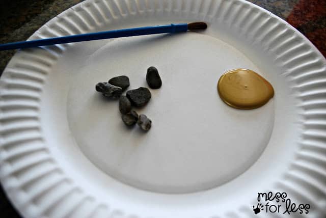 paper plate with rocks, gold paint and brush