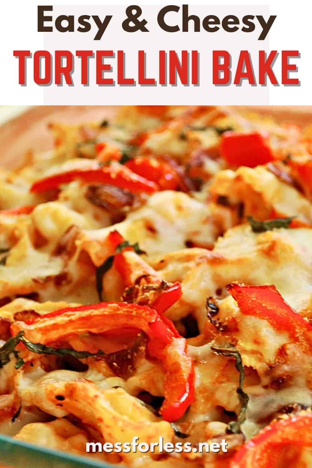 Close-up of a cheesy tortellini pasta bake with melted cheese, red peppers, and herbs in a bubbling baking dish.