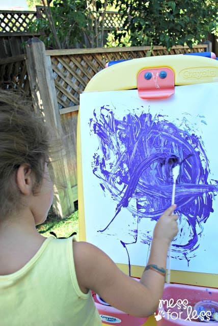  painting with rubber band paintbrushes on an easel