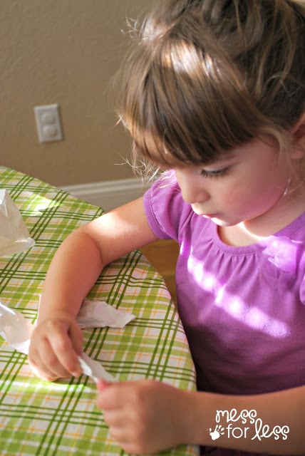 child tearing paper