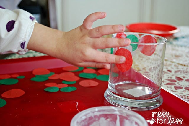 child gluing tissue paper on candle holder