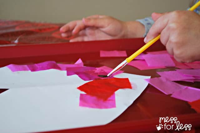 child placing Tissue paper on heart 