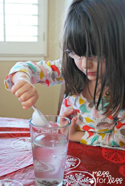 child adding vinegar to a glass