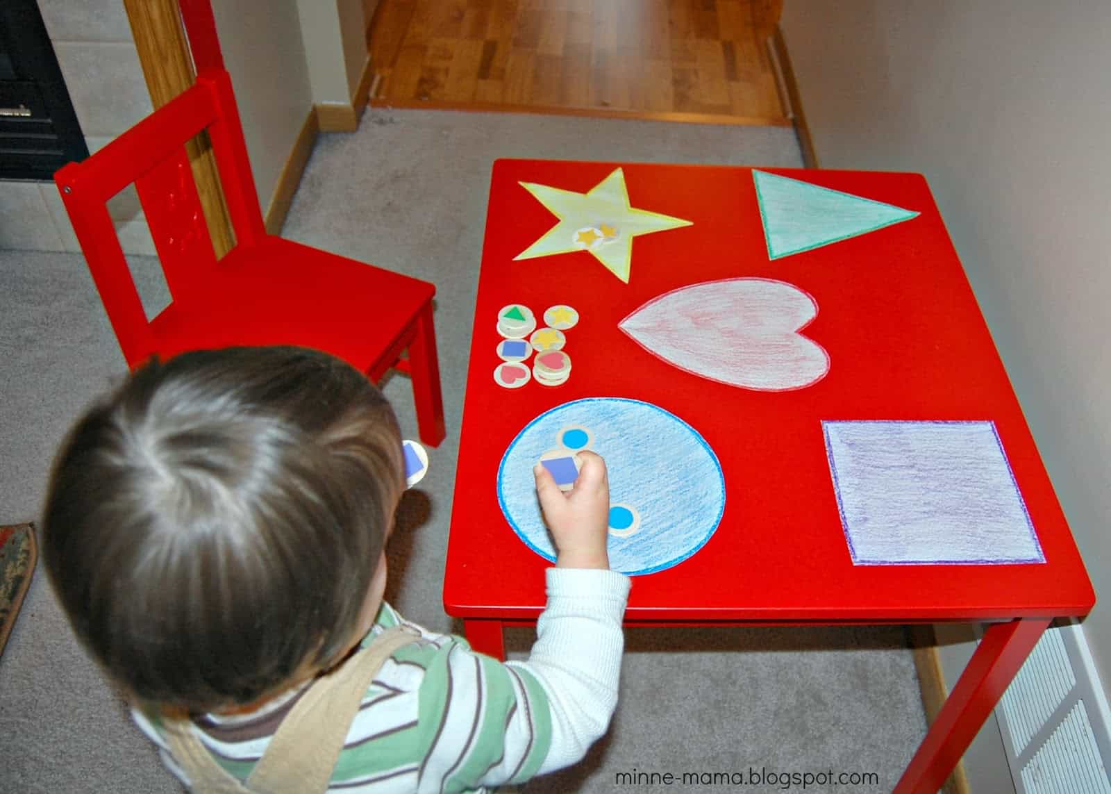 childing playing at red table with shape pictures