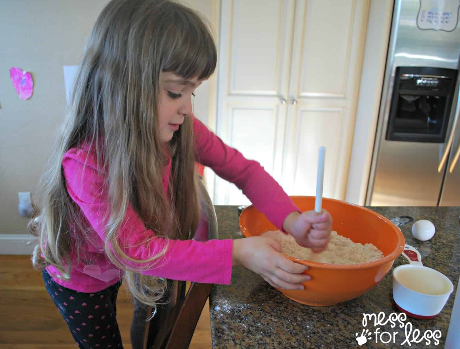 child stirring flour in a bowl