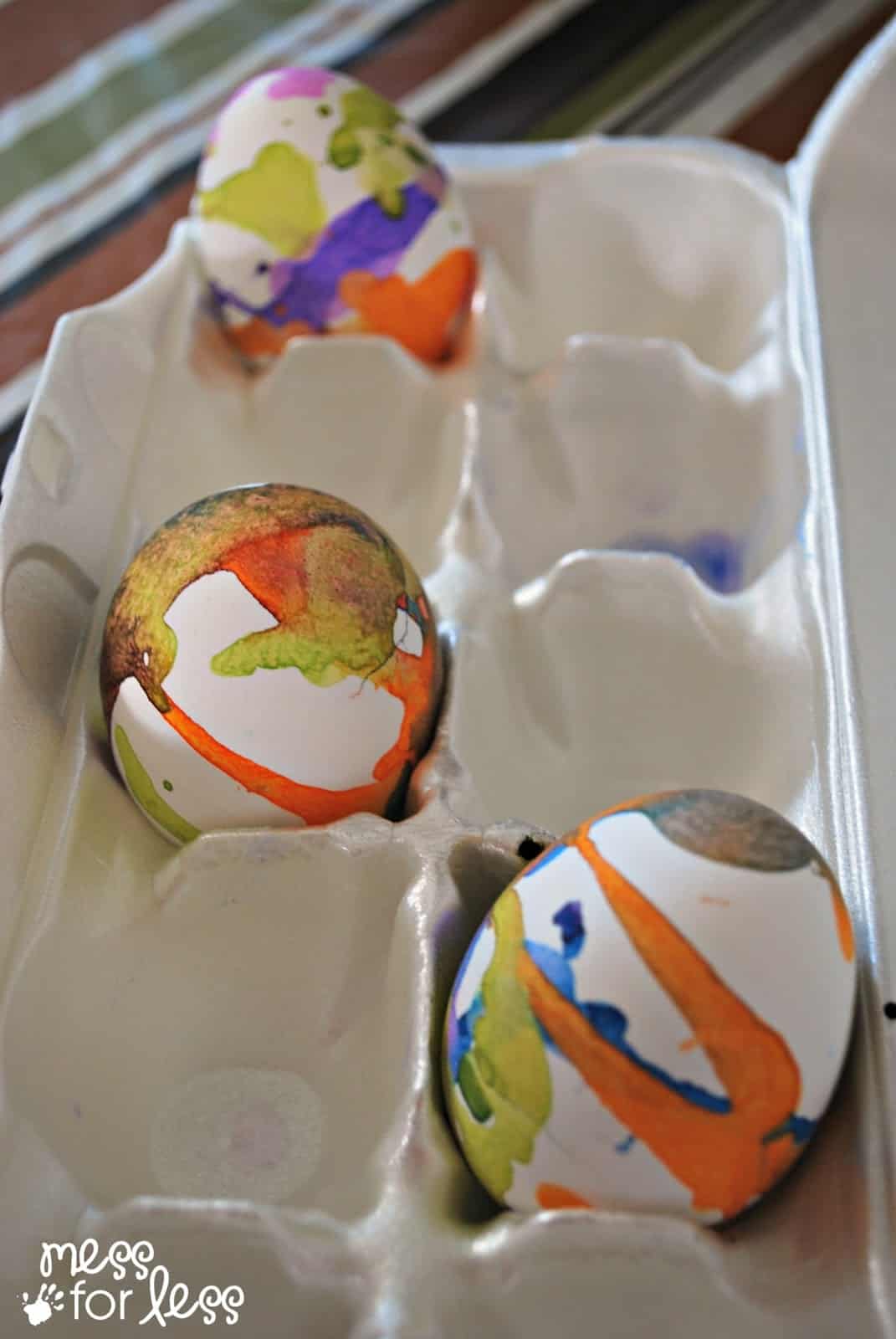 Liquid Watercolor Decorated Eggs in egg carton.