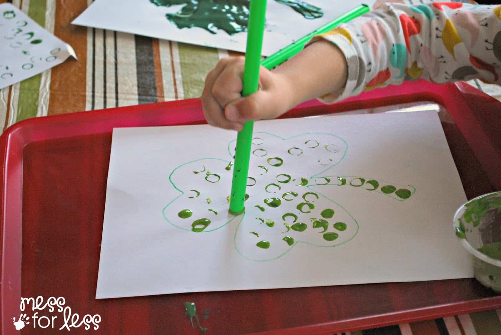 painting a paper shamrock with a straw