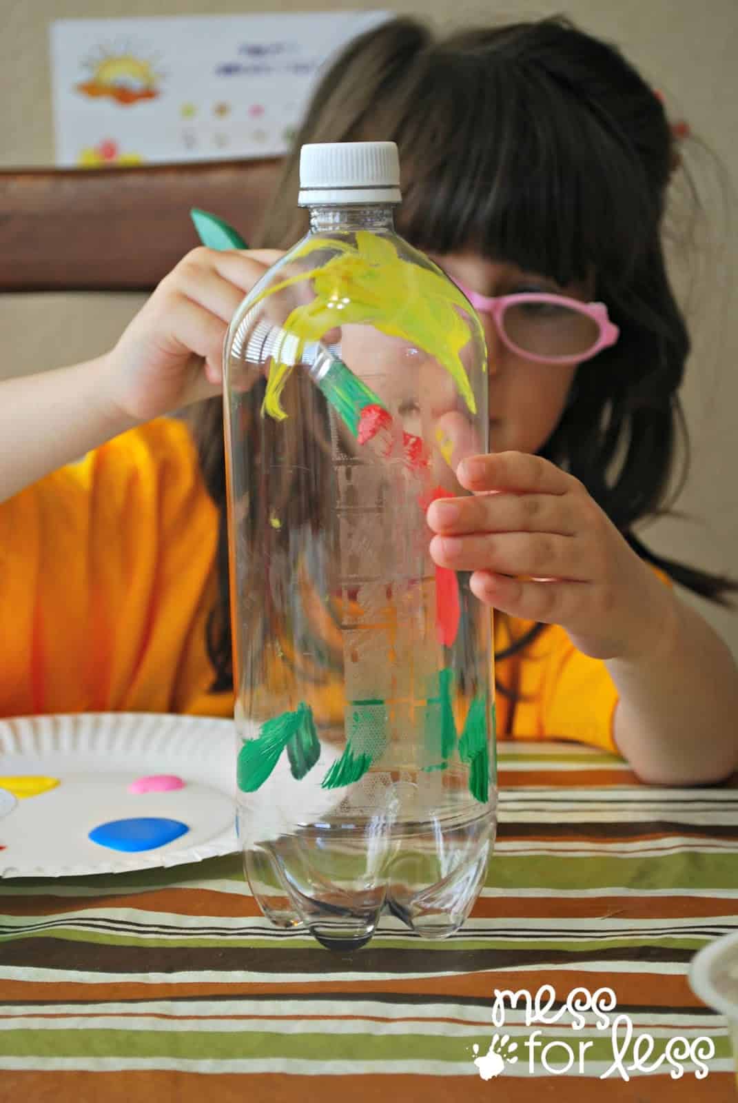 child painting plastic bottle