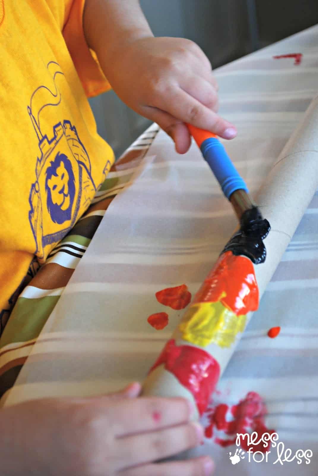 child painting a paper tube