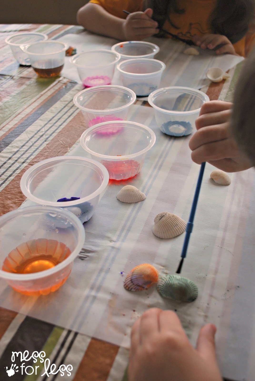 child painting shells with watercolor paint