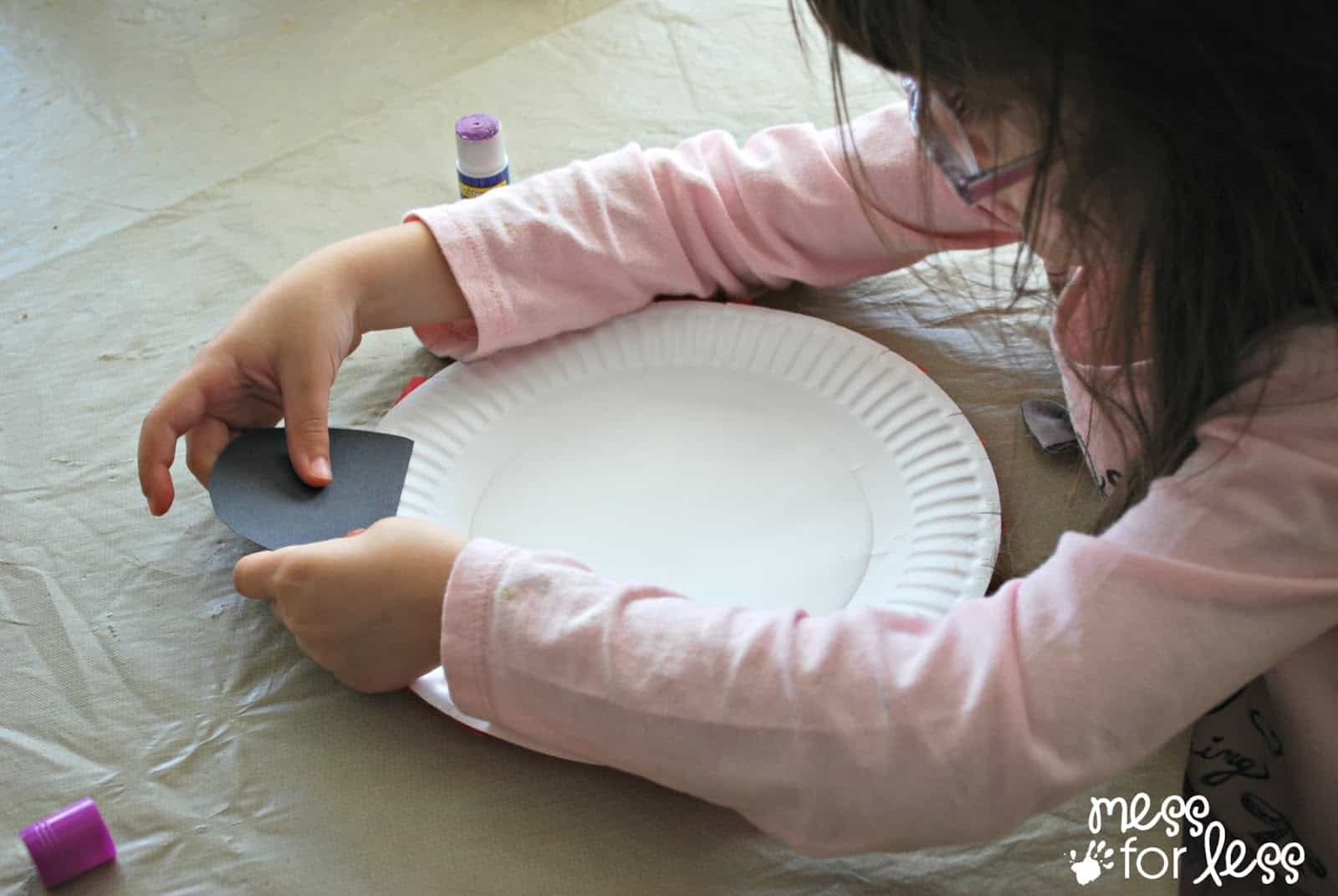 child decorating paper plate