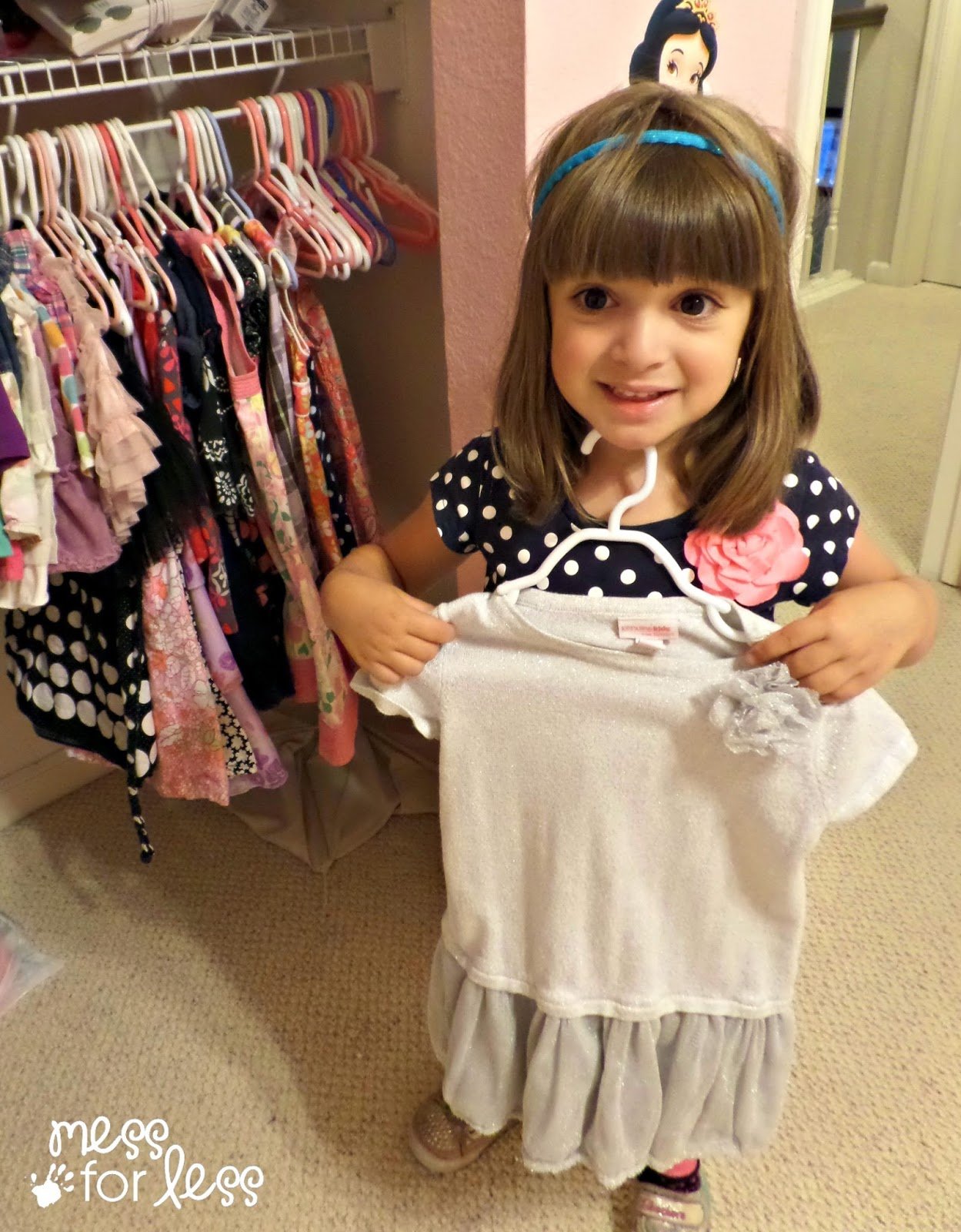 child putting clothes in the closet