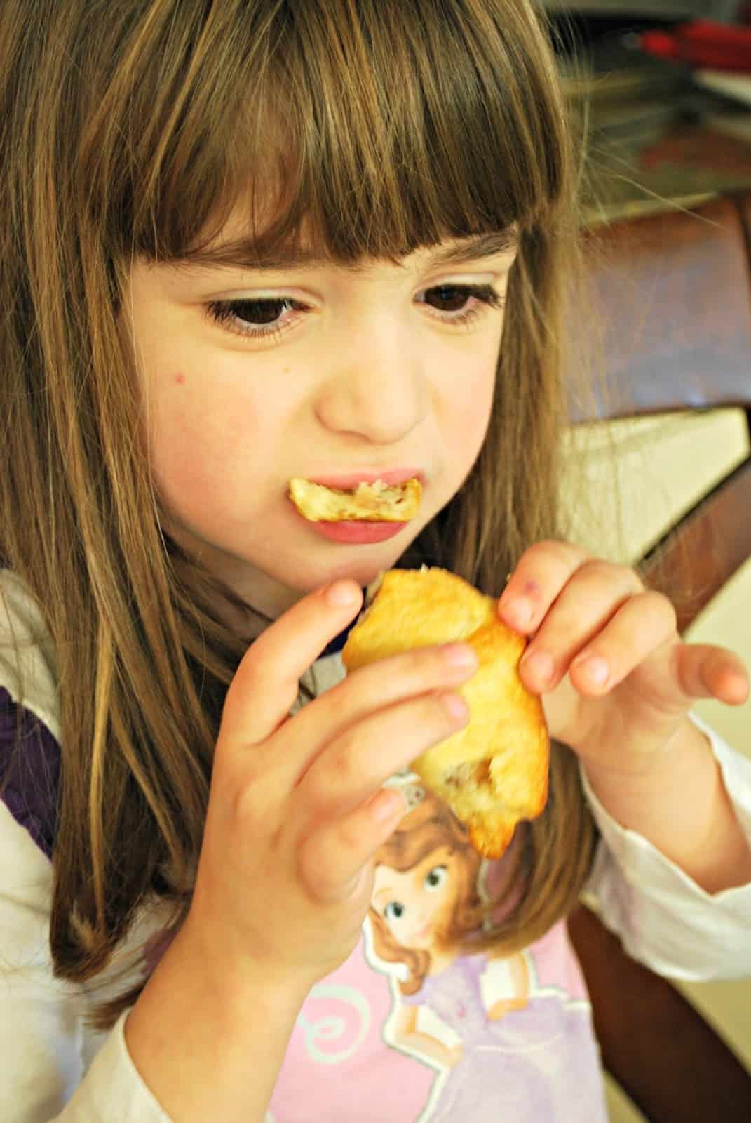 child eating crescent rolls