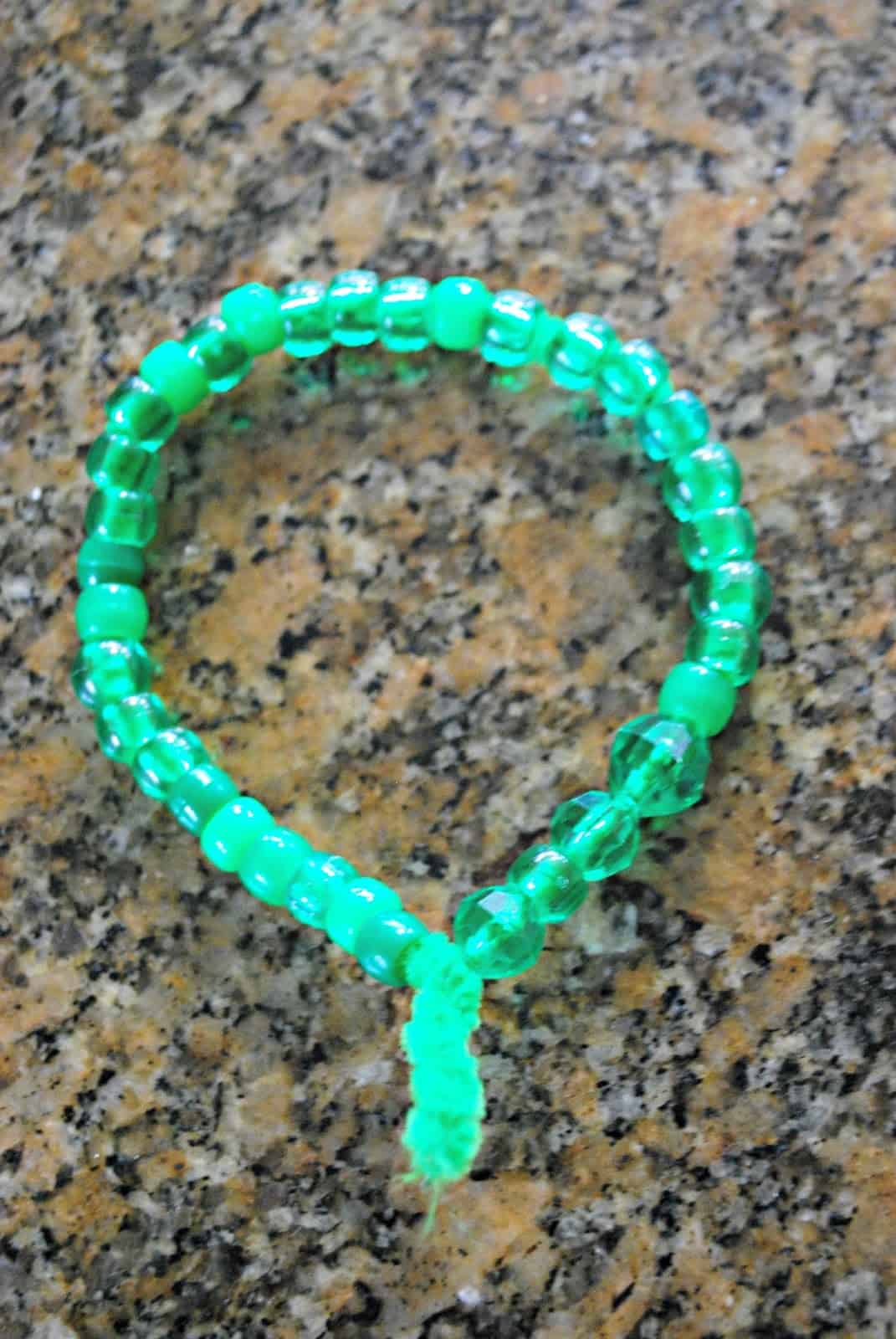 kids craft with green beads and pipe cleaner